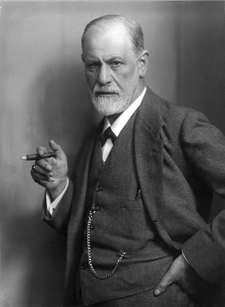 Portrait historique de Sigmund Freud dans son cabinet de travail, entouré de ses livres et de ses objets de collection psychanalytiques à Vienne.